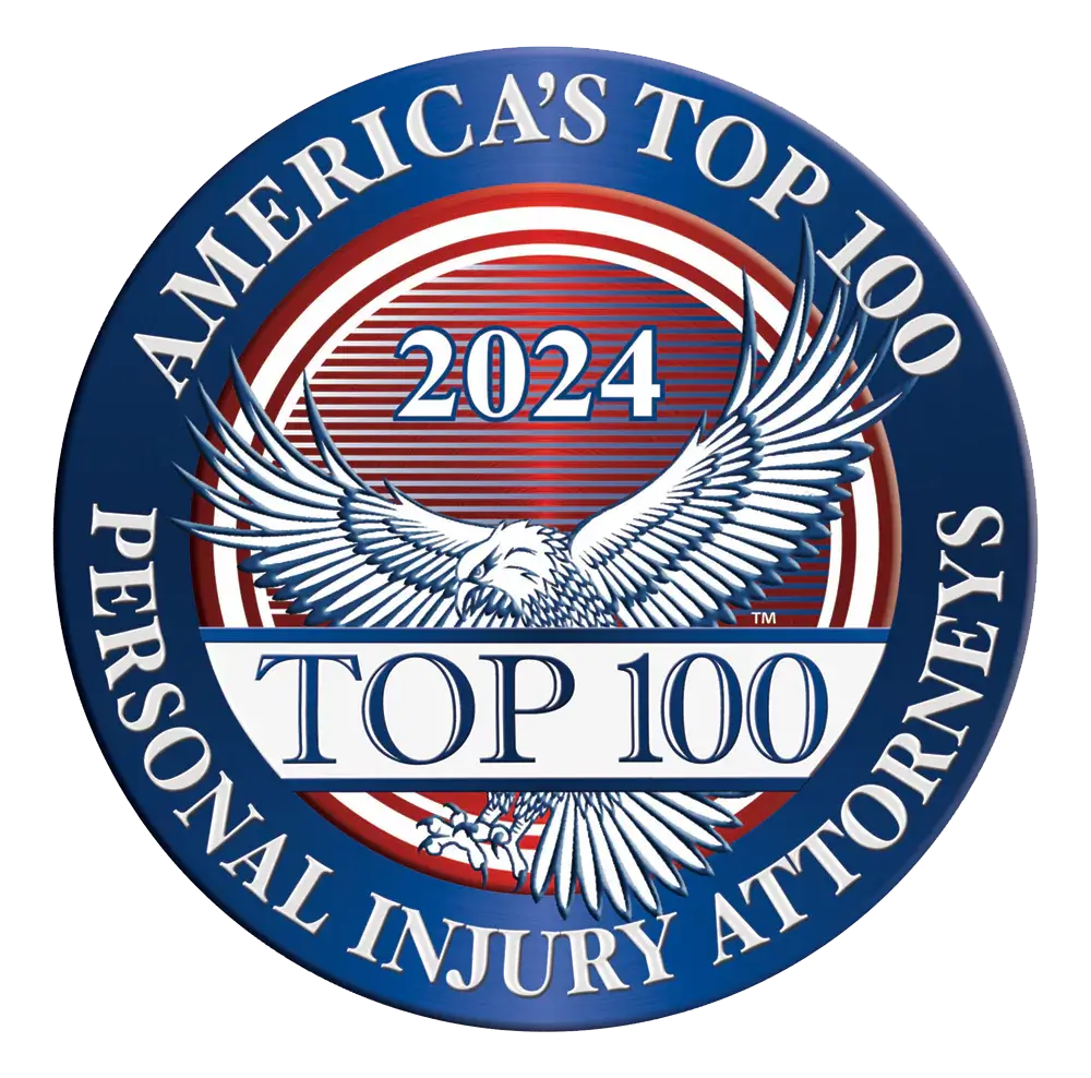 A circular badge reading Americas Top 100 Personal Injury Attorneys 2024, featuring a central illustration of a bald eagle.
