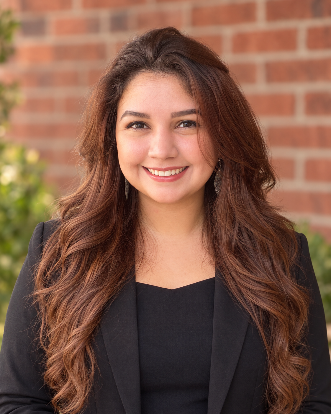 A woman smiling in a professional black blazer.